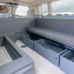Mesa campervan with all under-bench drawers pulled out, showing empty storage compartments ready for packing.