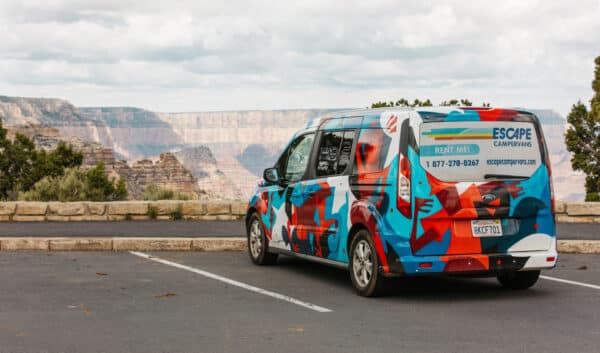 Escape camper van parked in front of the Grand Canyon representing why a van is better than an rv