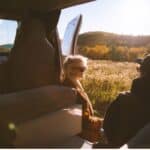 People sitting in a camper van on a Vermont road trip
