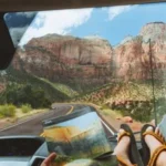 A person holding a Zion park map while driving into Zion National Park on a road trip.