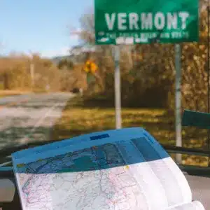 A map and the Welcome to Vermont sign.