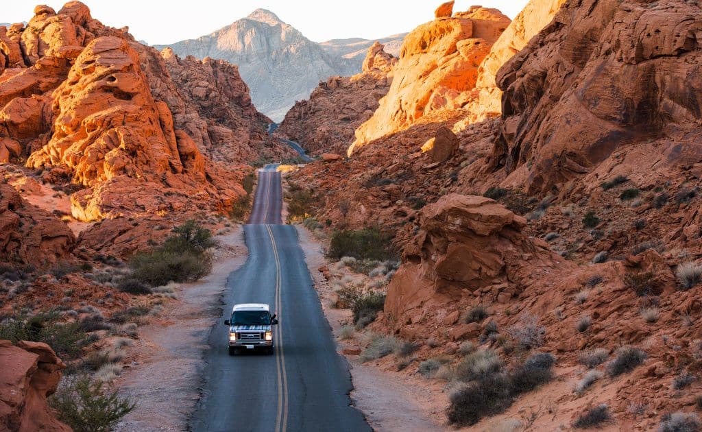 An escape camper van driving through the Valley of Fire in Nevada.