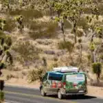An escape camper van driving through joshua tree national park