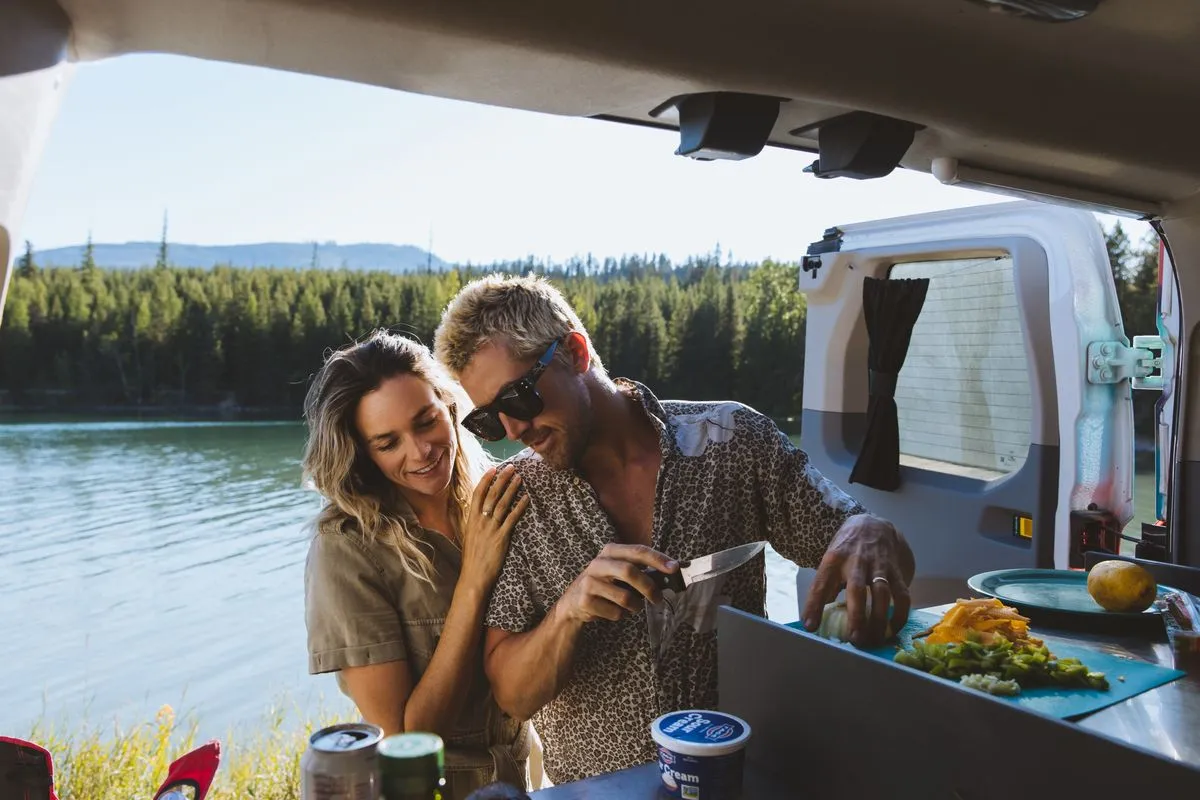 A couple making lunch out of an Escape Campervan.