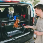 A man making pasta in the back kitchen of an Escape Campervan