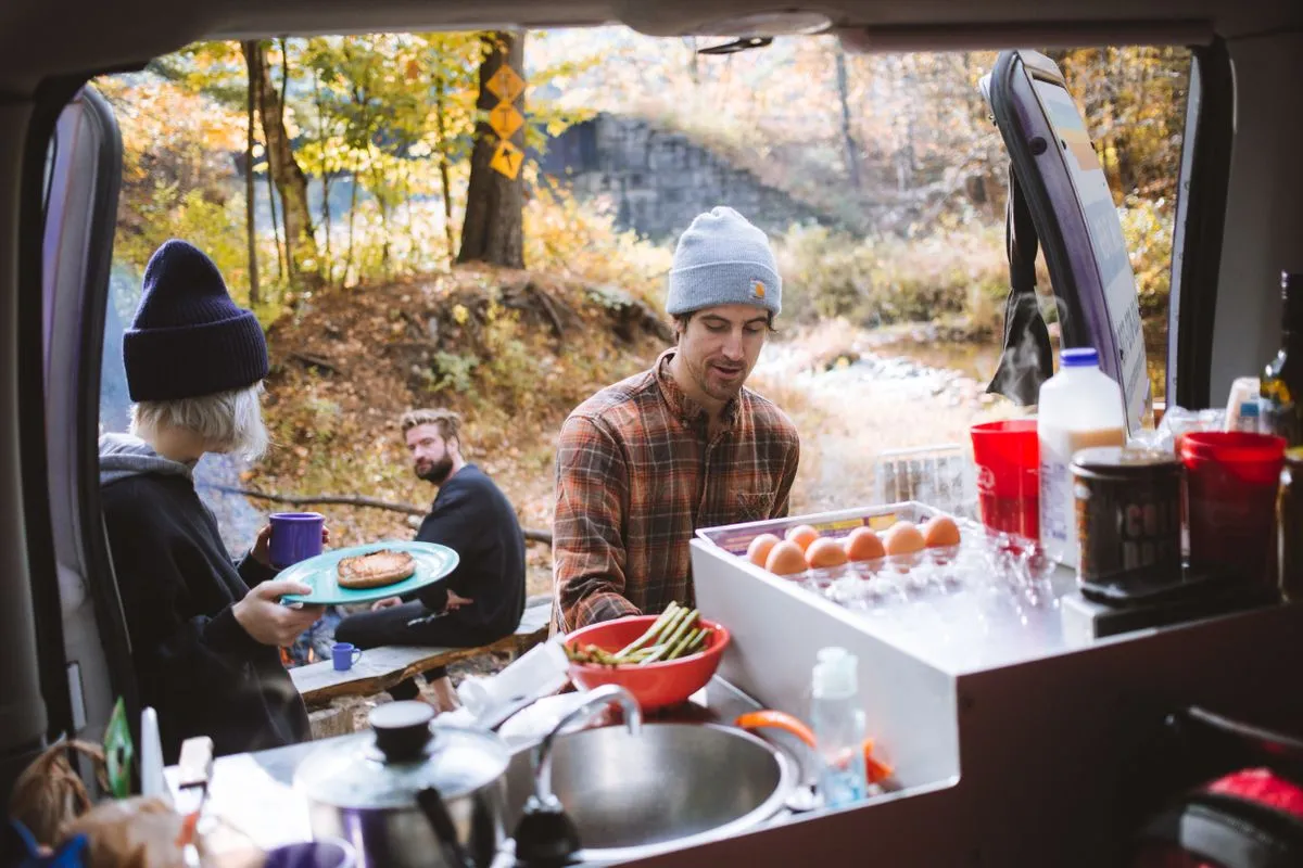 A group of friends cooking and easy camping breakfast together.