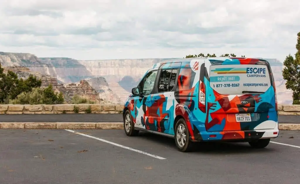 An Escape Camper Van parked next to the Grand Canyon.